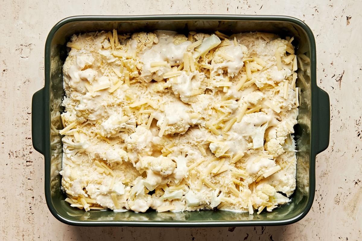 cauliflower au gratin made with milk, Parm, Gruyère, butter, spices & shallot in a baking dish ready for the oven