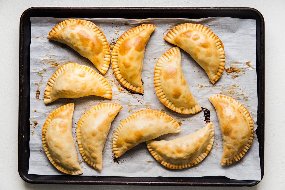 10 chicken empanadas on a baking sheet fresh out of the oven