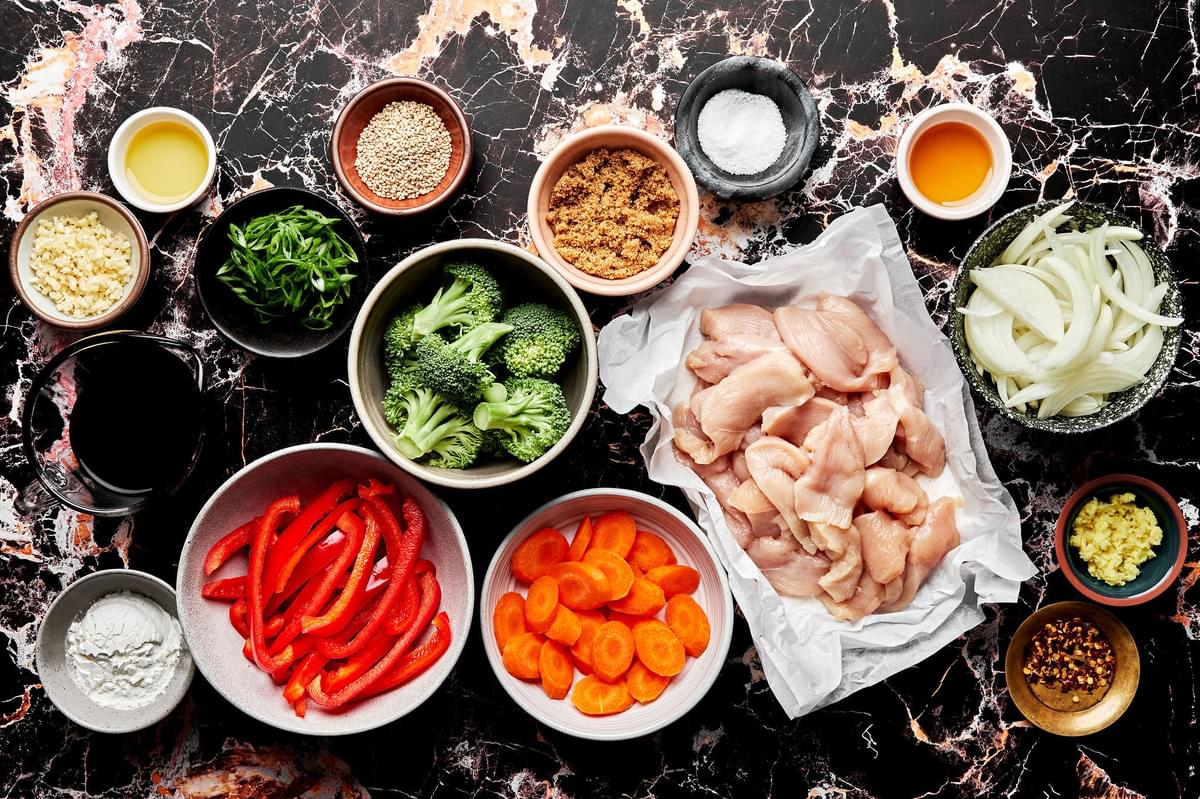 chicken, vegetables, tamari, sesame oil, vegetable oil, sesame oil and green onions in prep bowls
