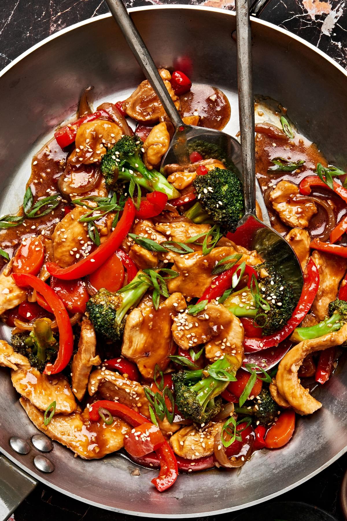 chicken stir fry in a pan made with broccoli, onion, bell pepper, carrots and homemade stir fry sauce