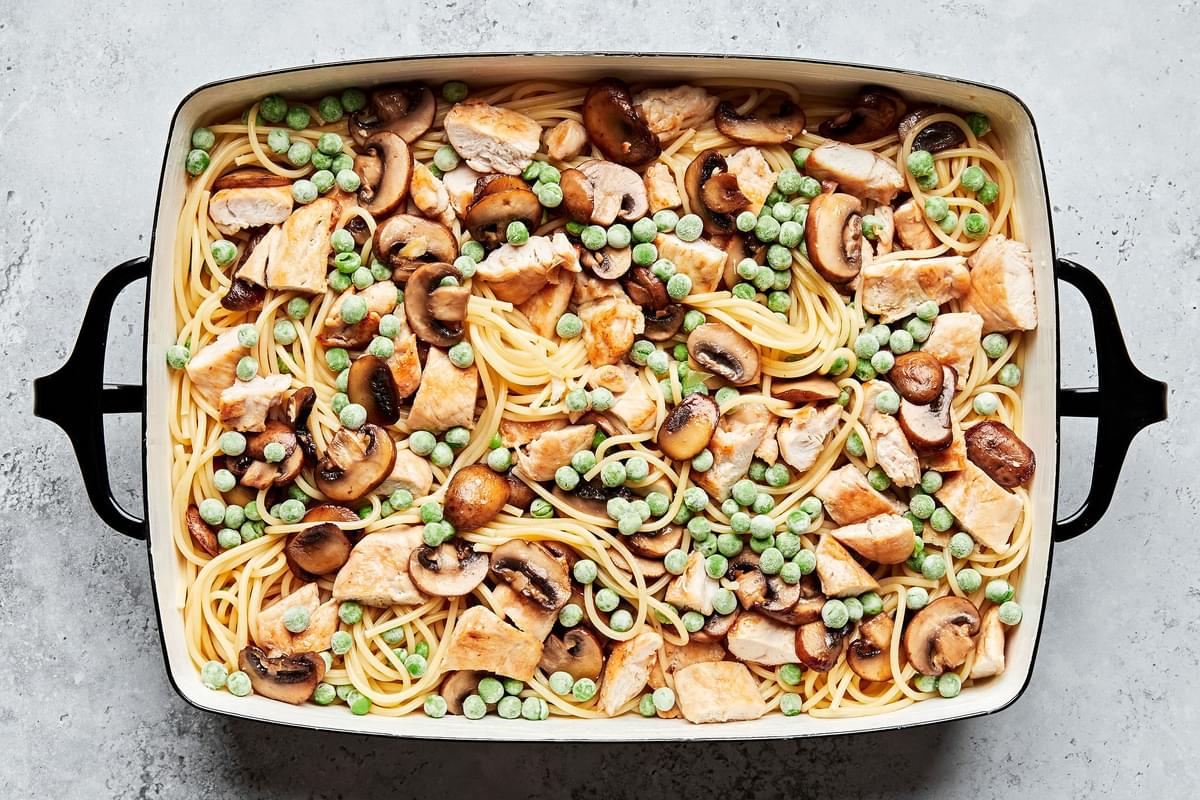 chicken, spaghetti noodles, peas and mushrooms combined in a 9x13 casserole dish