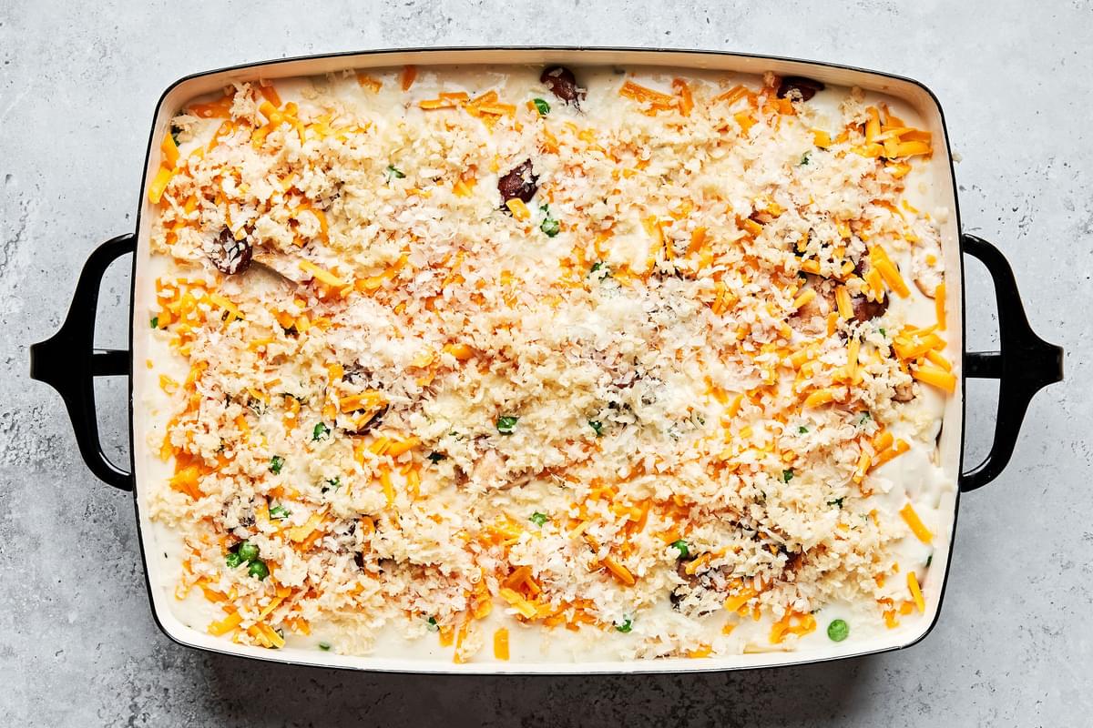 chicken, noodles, peas and mushrooms covered in cream sauce and topped with cheddar and Parmesan cheeses in a baking dish