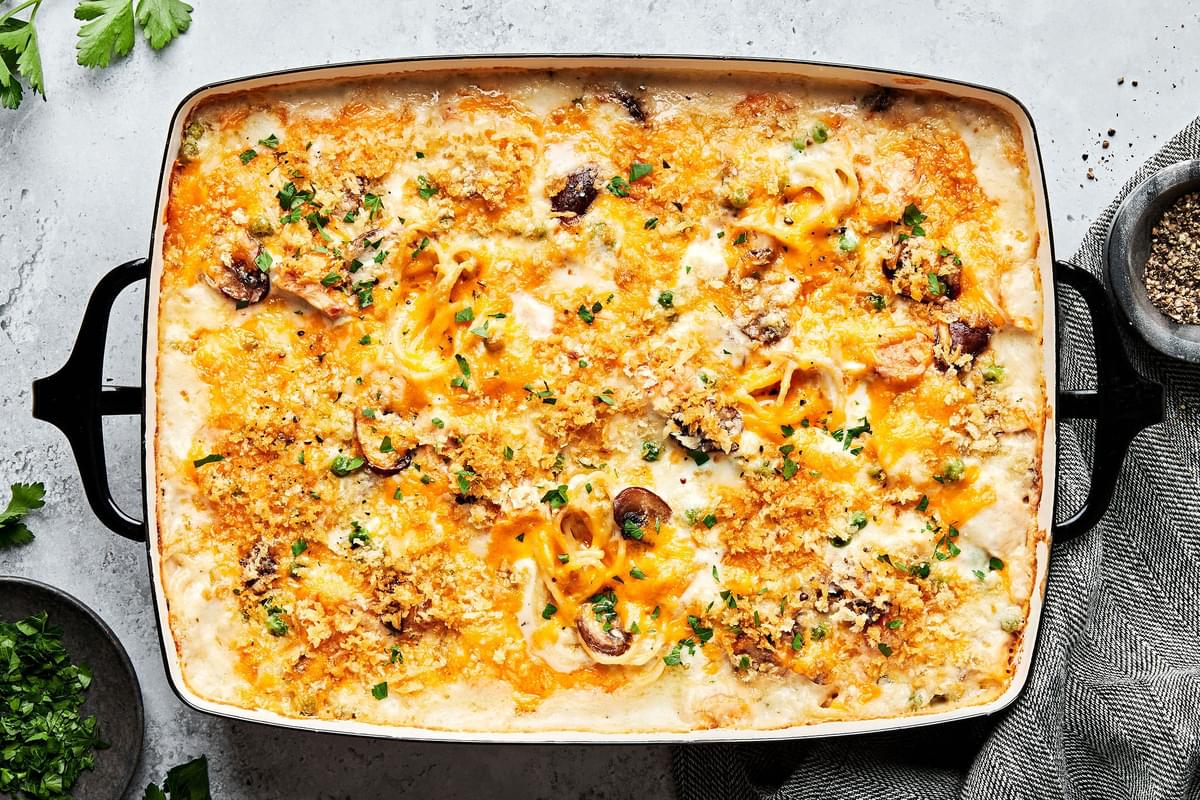 chicken tetrazzini in a baking dish made with noodles, mushrooms, peas, cream sauce, cheddar, Parm and panko in a baking dish