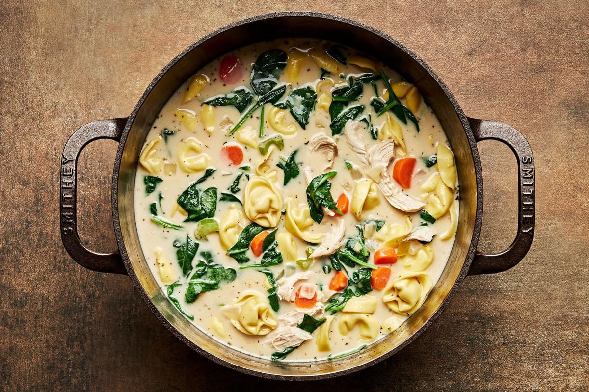a pot of chicken tortellini soup made with cream, parmesan, spinach, pepper, salt, paprika and italian seasoning