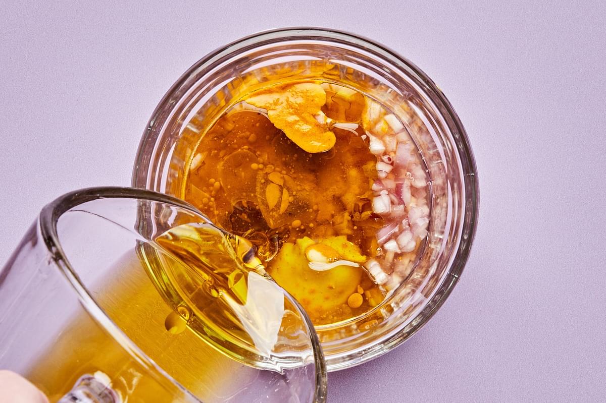olive oil, apple cider vinegar, shallot, turmeric, mustard, honey & salt being mixed in a jar to make turmeric vinaigrette