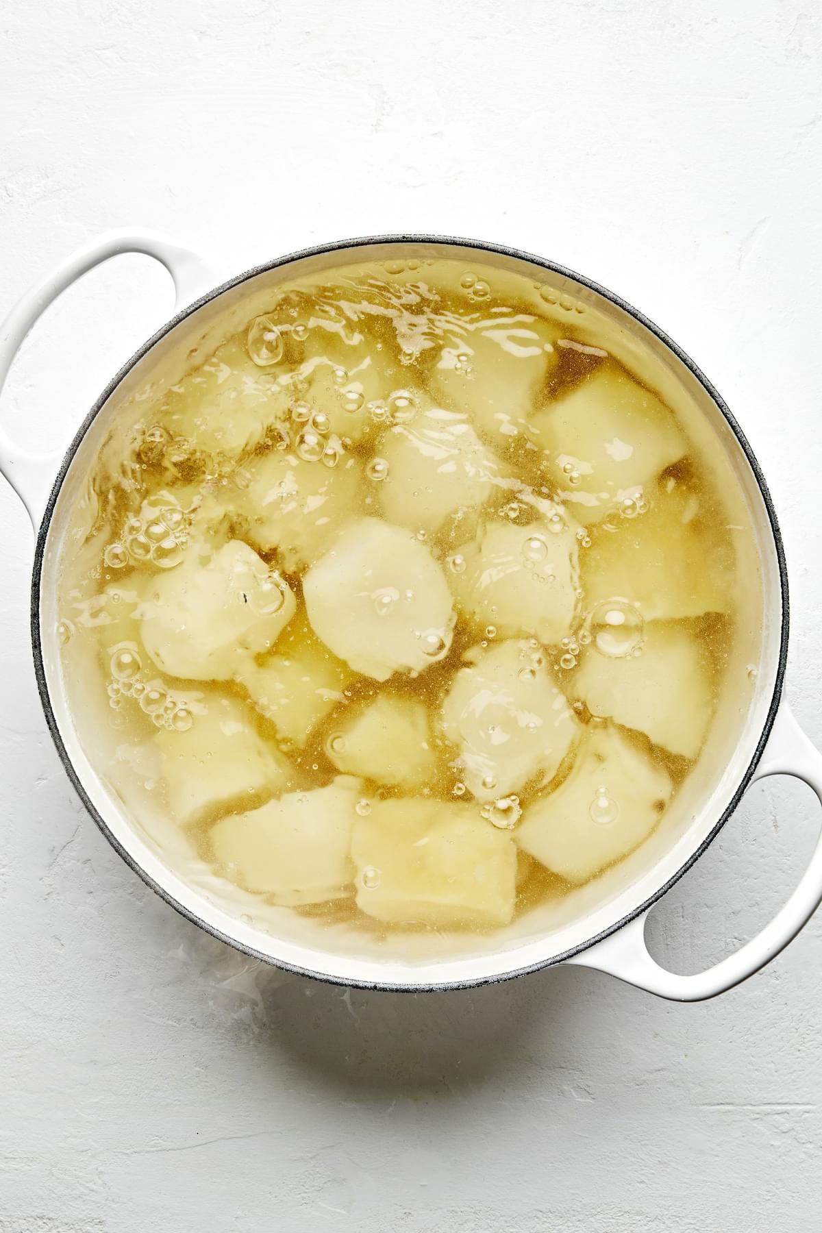 russet potatoes being boiled in a pot of water to make classic mashed potatoes