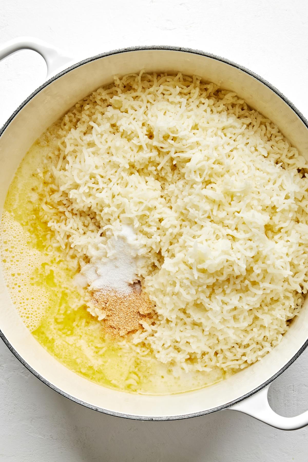 riced potatoes in a pot with warm whole milk, melted butter, salt and garlic powder