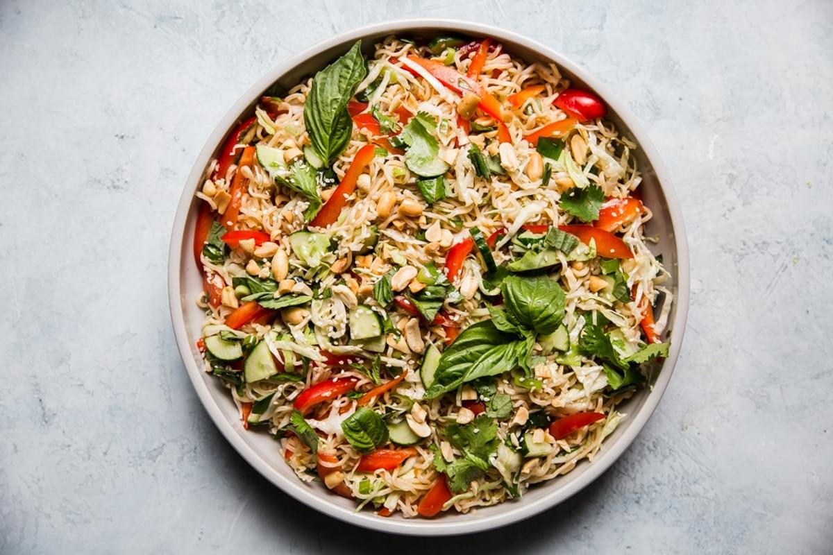 cold ramen salad in a bowl with basil, sesame seeds, red bell peppers and cucumber