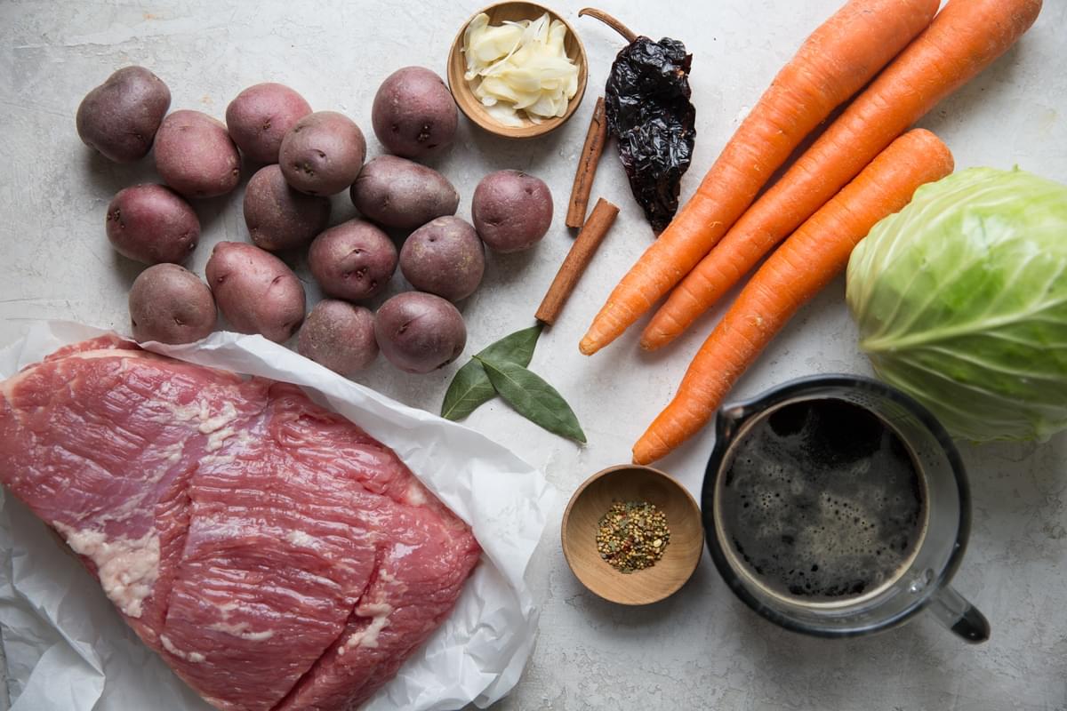 ingredients for corned beef, beef stock, carrots, cabbage, potatoes, cinnamon sticks