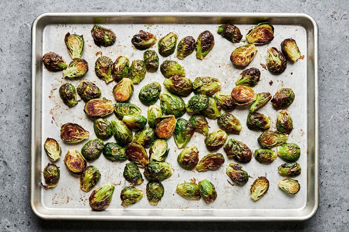 roasted brussels sprouts seasoned with olive oil and salt on a baking sheet