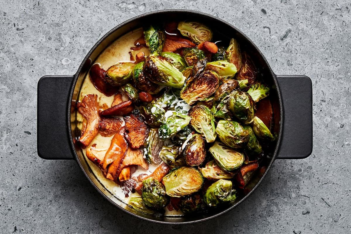 mushrooms, white wine, roasted brussels sprouts and heavy cream cooking in a large pot