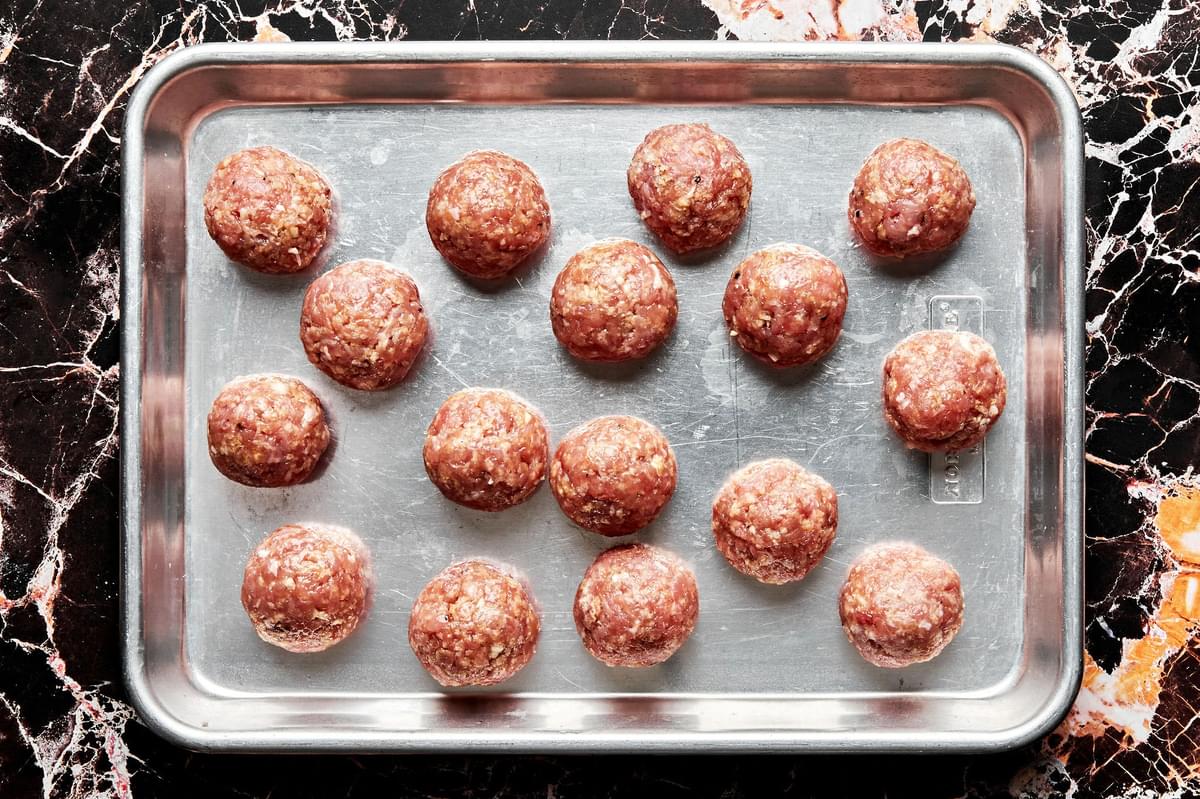raw turkey meatballs on a baking sheet made with ground turkey, breadcrumbs, spices, Worcestershire, and egg