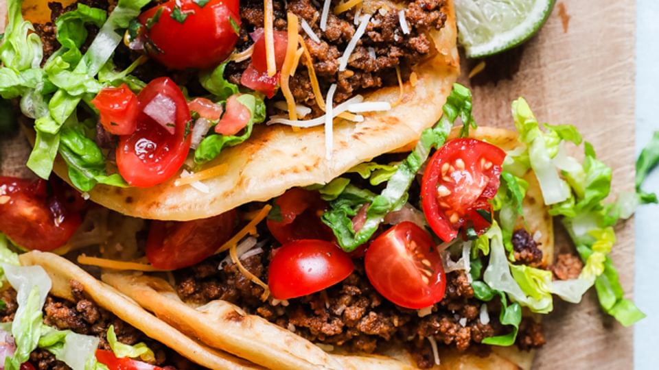 Crispy tortillas with ground Beef Taco meat, cheese lettuce and lime
