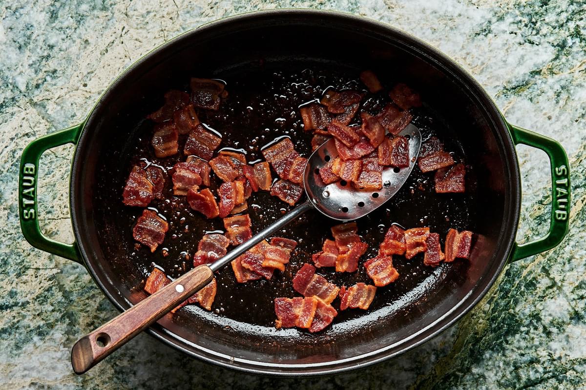 chopped bacon being cooked in a dutch oven