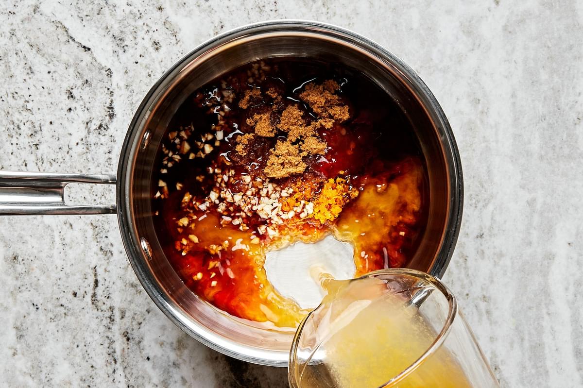 orange zest, orange juice, soy sauce, chili-garlic paste, sugar, garlic, and rice wine vinegar. being combined in a sauce pan