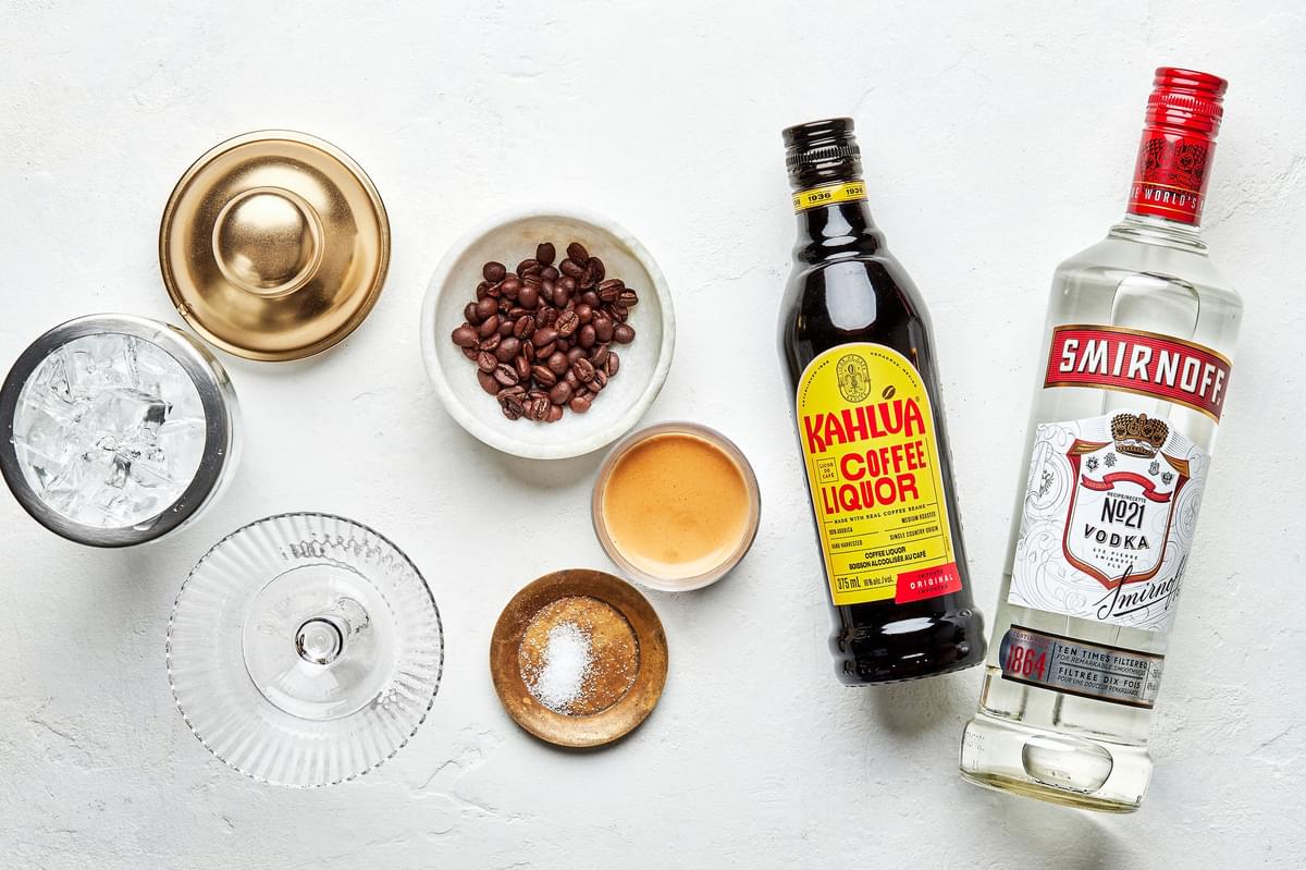 vodka, kahlua, espresso, salt and coffee beans on the counter to make an espresso martini