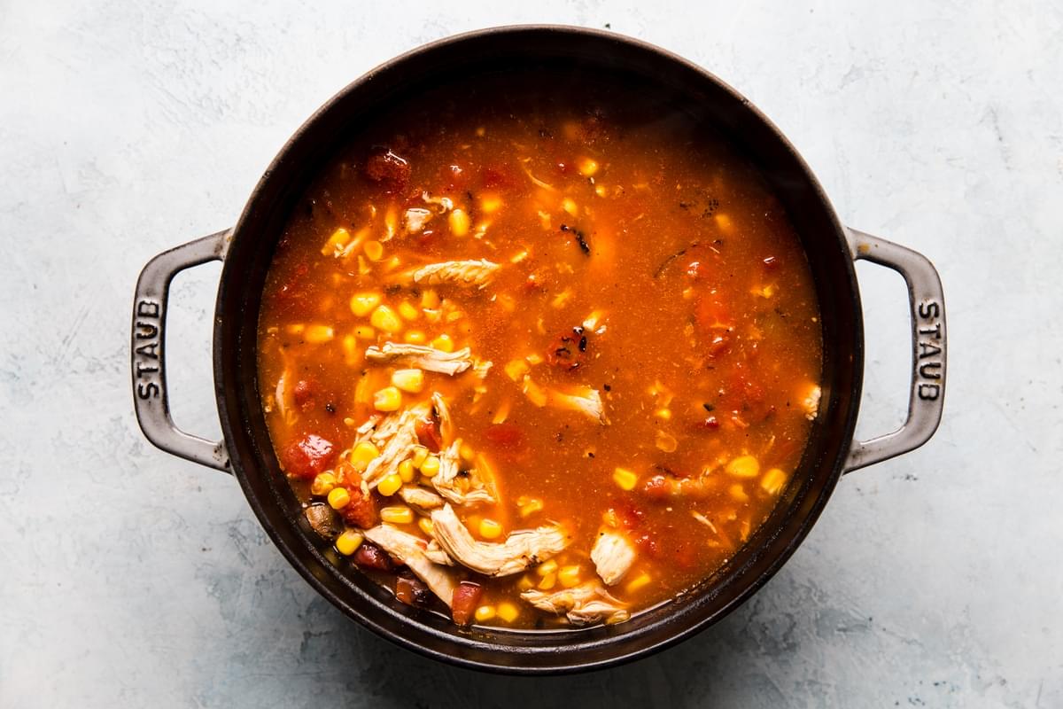 corn, chicken stock, shredded rotisserie chicken, canned tomatoes and enchilada sauce mixed together in a soup pot.