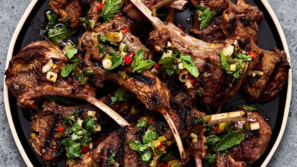 Garam Masala Grilled Lamb Chops on a serving plater next to a small bowl filled with Mint Chutney