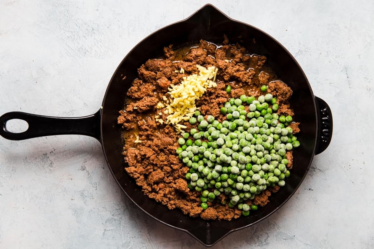 ground beef, peas and ginger in a cast iron skillet