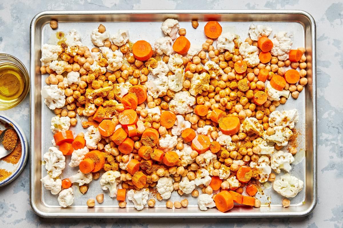 chickpeas, cauliflower and carrots tossed with olive oil, curry powder, turmeric, salt and cayenne on a baking sheet