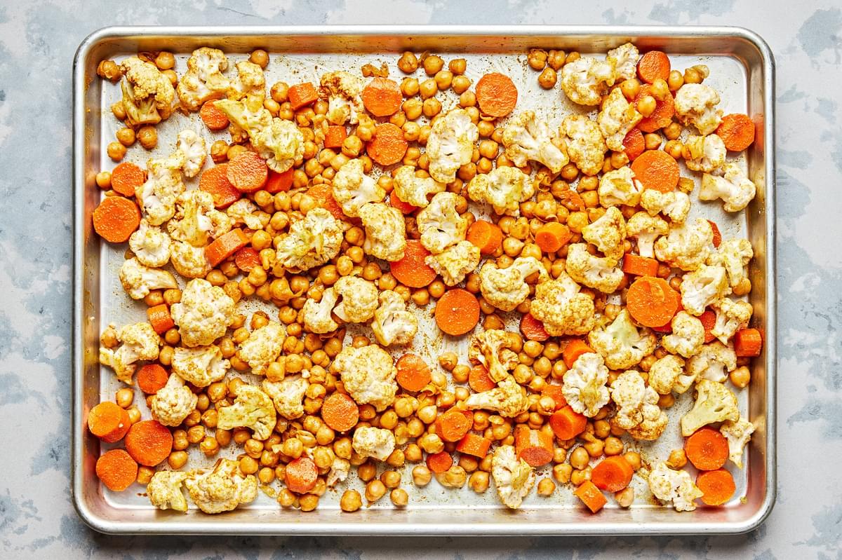 chickpeas, cauliflower and carrots tossed with olive oil, curry powder, turmeric, salt and cayenne on a baking sheet