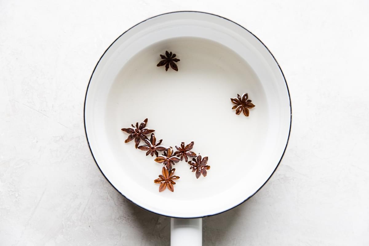 star anise simple syrup in a small white pot
