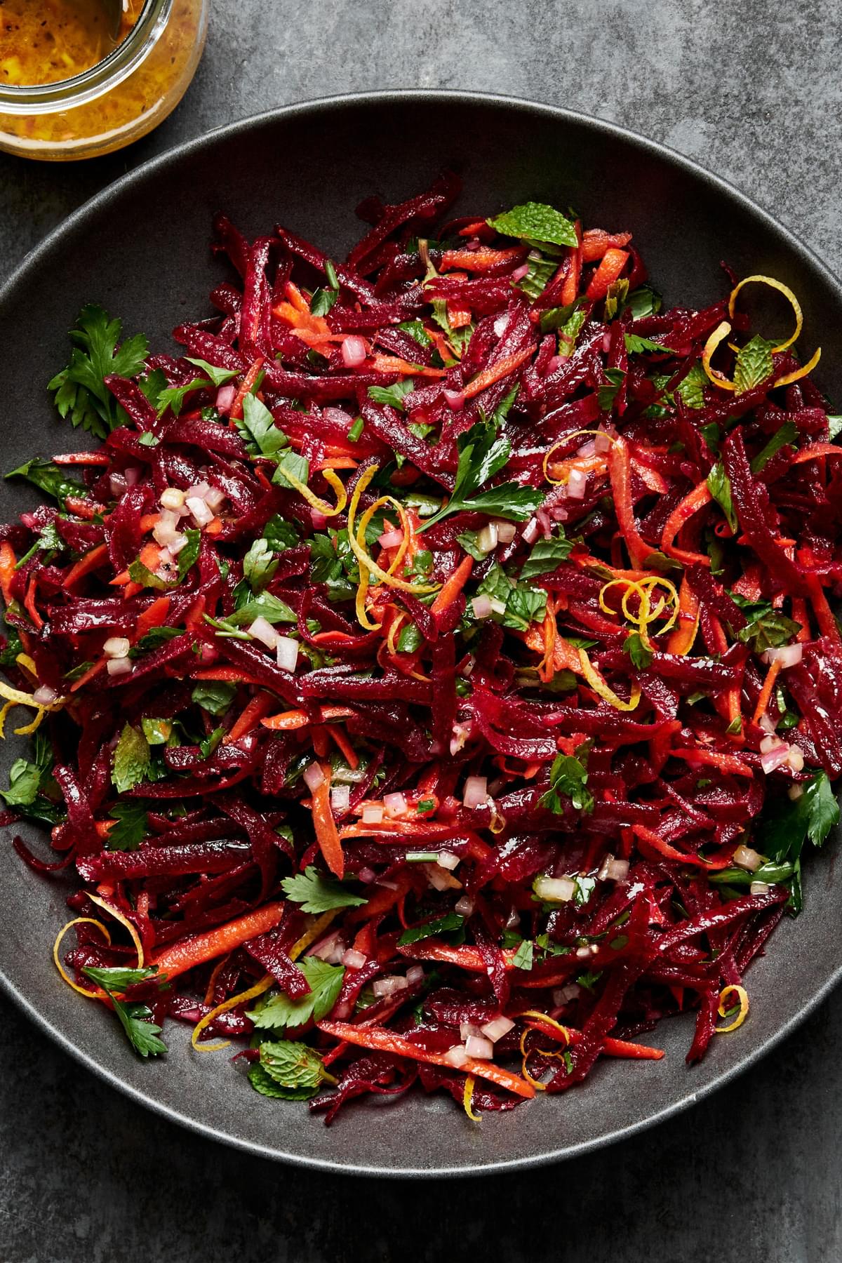 grated beet salad made with grated carrots, parsley, mint and homemade honey mustard dressing in a serving bowl