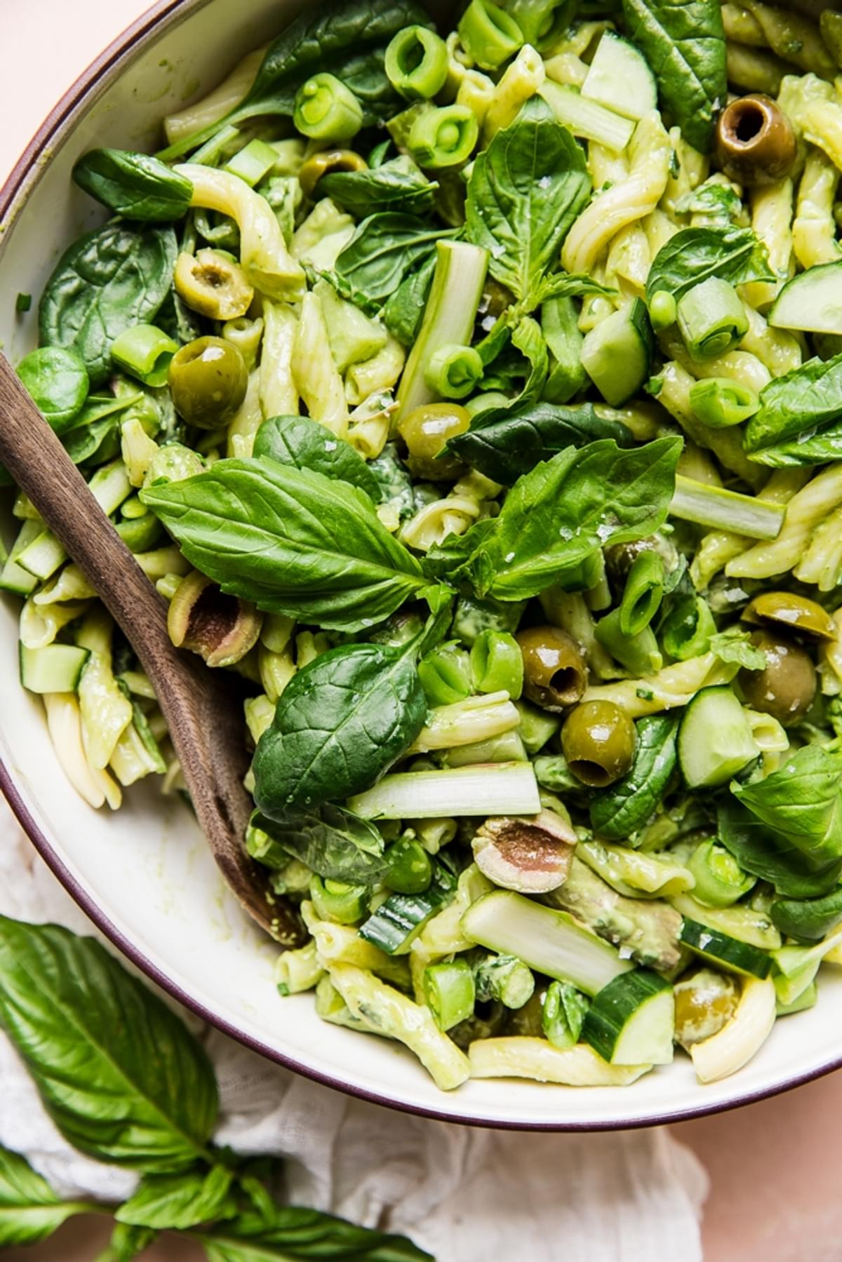 green pasta salad with spinach, cucumber, asparagus, green olives and cucumbers