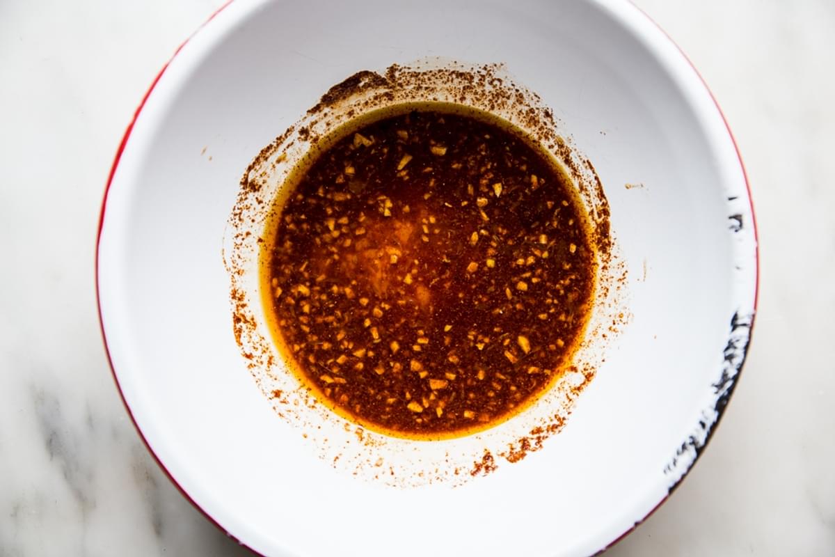 marinade for grilled scallops in a bowl with garlic, lemon, honey and olive oil