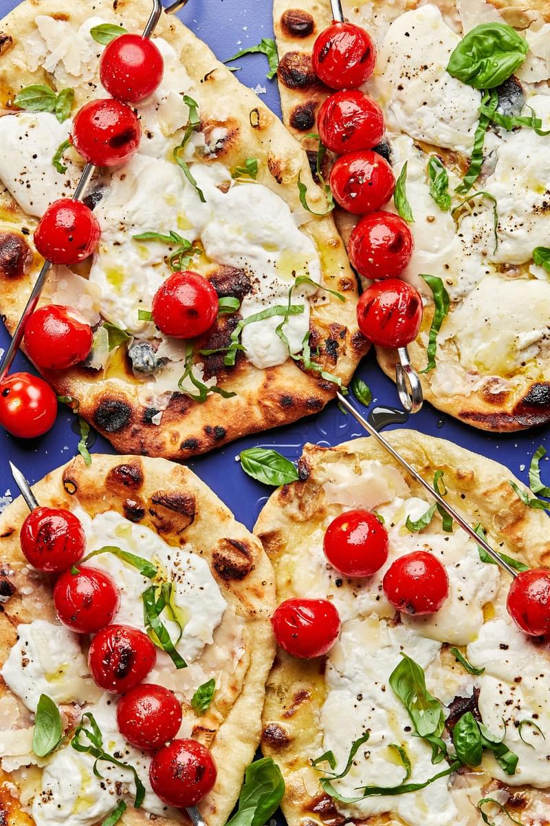 grilled flatbread topped with burrata cheese, fresh basil and grilled tomato skewers