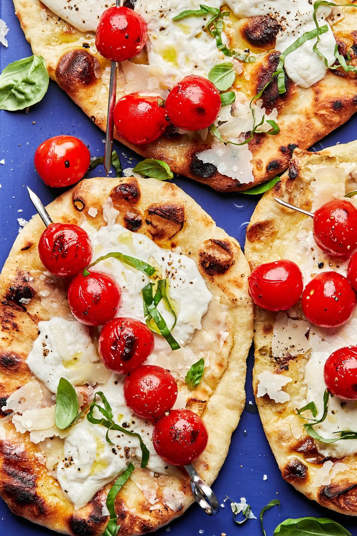 grilled flatbread with burrata cheese topped with fresh basil grilled tomato skewers