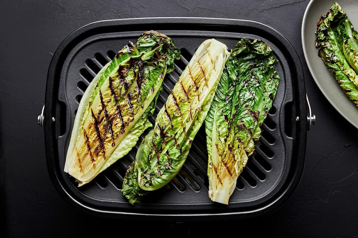 romaine letruce brushed with olive oil being grilled