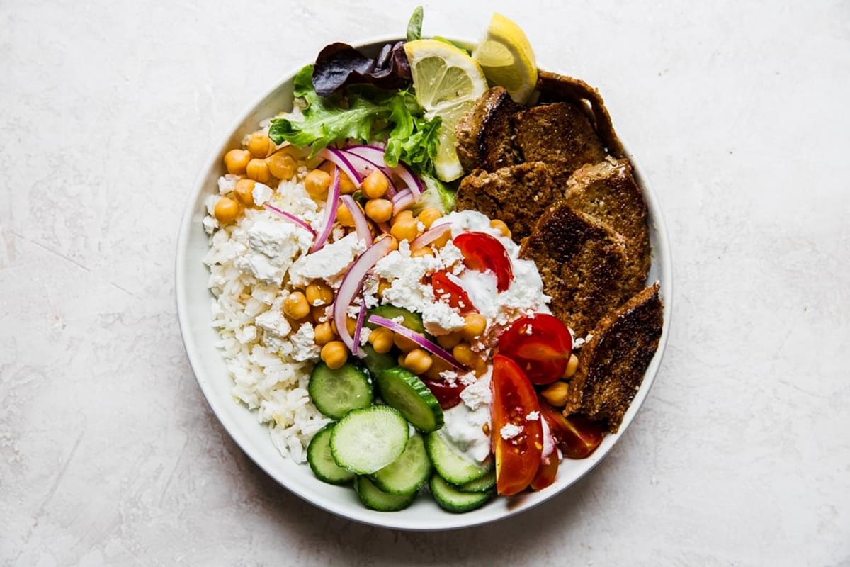 gyro bowl with cucumbers, lemon rice, feta, red onion, tomatoes, lettuce and gyro meat