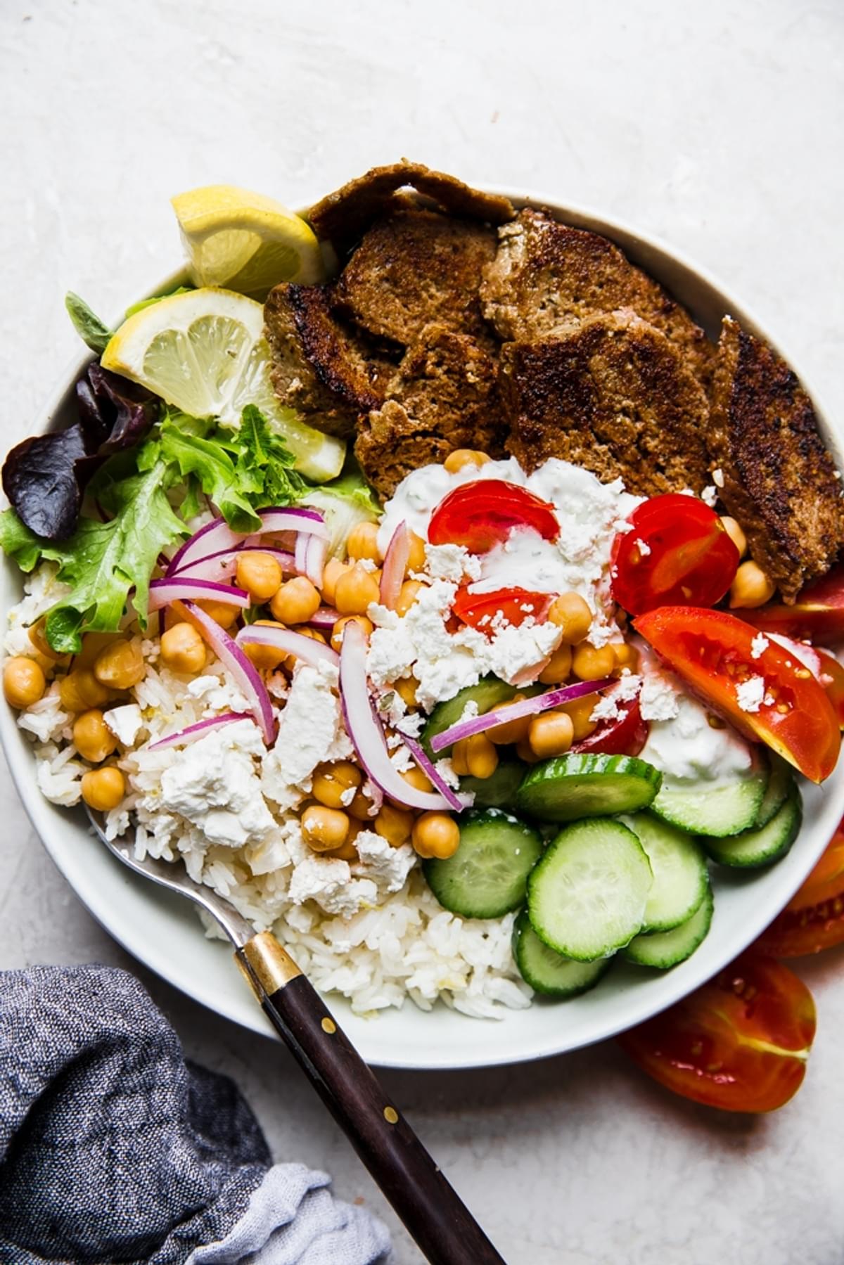 gyro bowl with cucumbers, lemon rice, feta, red onion, tomatoes, lettuce and gyro meat