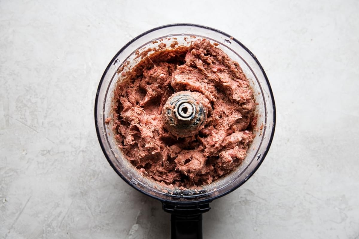 Homemade gyro meat in the base of a food processor made with ground beef, ground lamb, minced onion and spices
