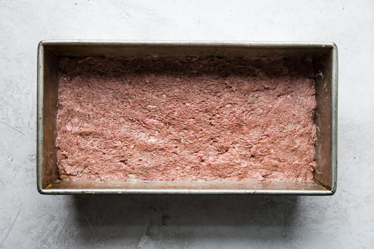 Homemade gyro meat in a loaf pan made with ground beef, ground lamb, minced onion and spices