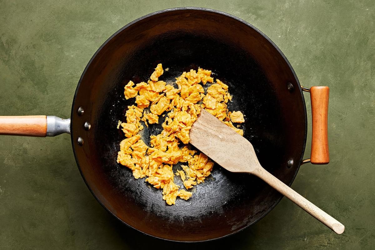 egss whisked with coconut aminos and sesame oil being scrambled in a skillet-