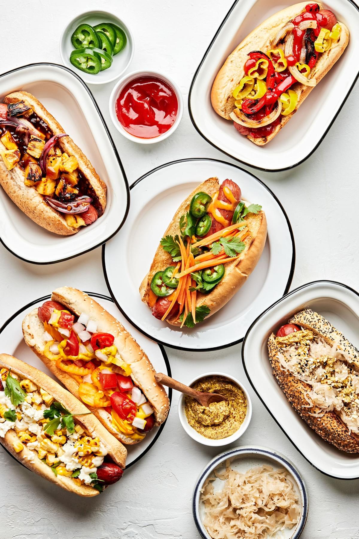 different style hot dogs one plates like hawaiian, italian-american , mexican, banh mi, chicago and the deli dog