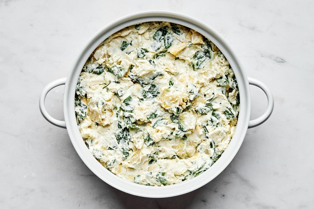 spinach and artichoke dip in a baking dish ready for the oven