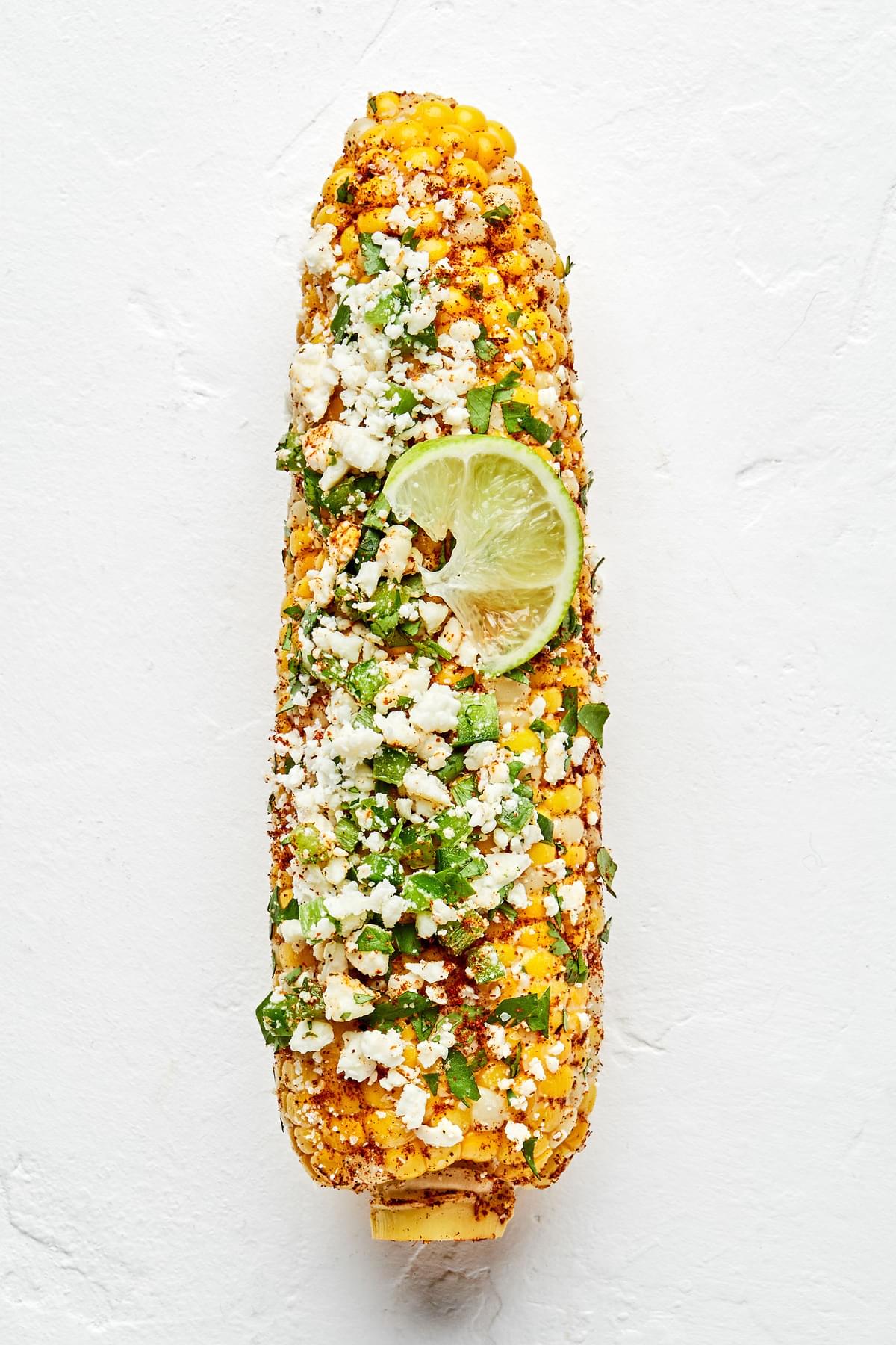 a grilled corn on the cob seasoned with butter, salt, chili powder, jalapeño, cilantro and Cotija Cheese