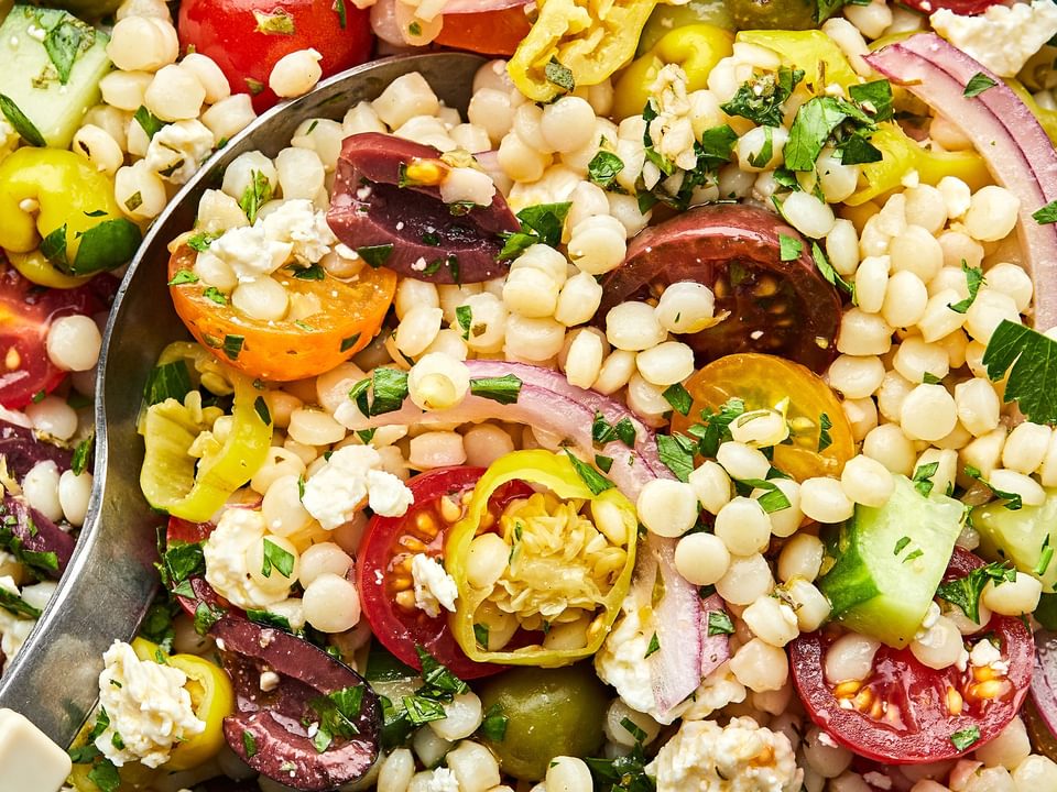 mediterranean couscous salad made with feta, Greek olives, cucumber, tomato, pepperoncini, red onion and parsley