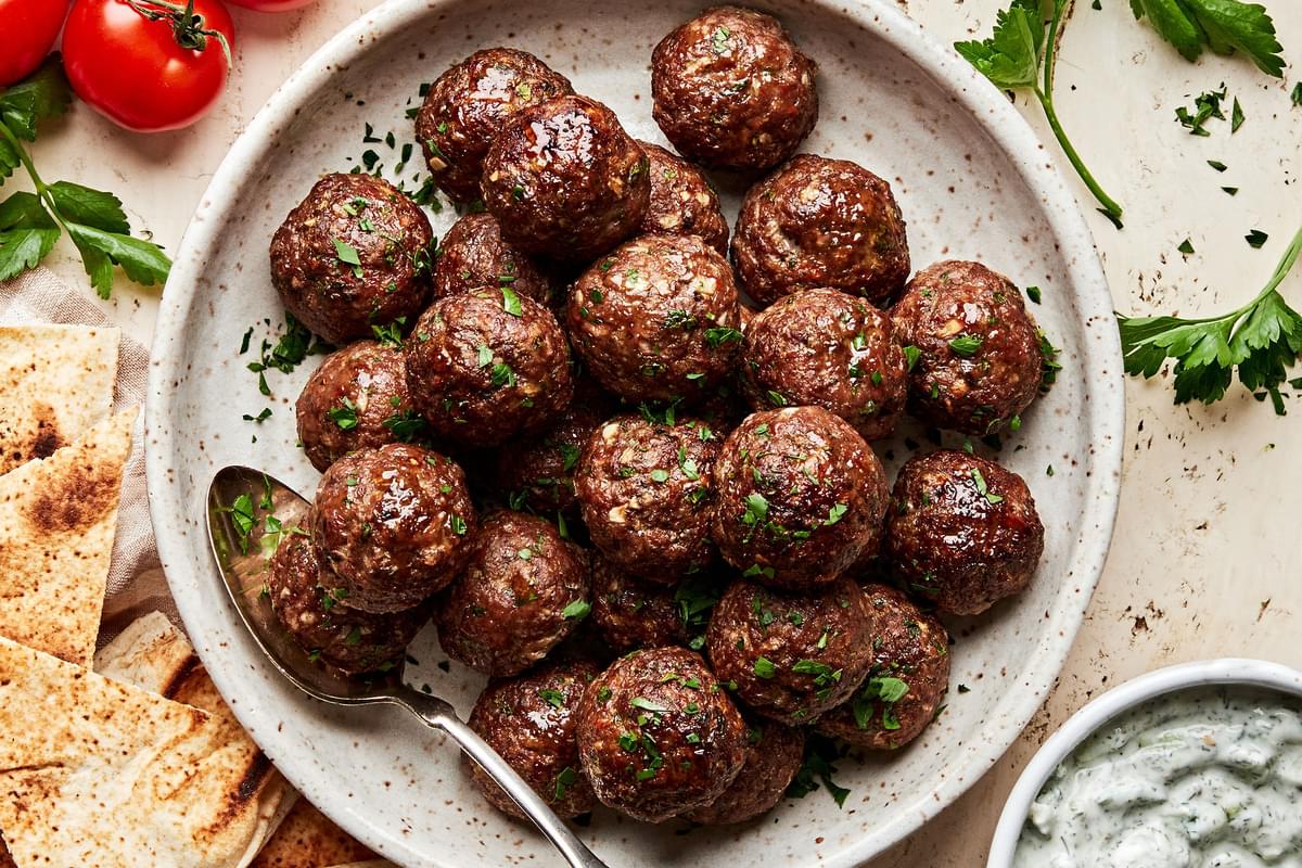 a bowl of mediterranean meatballs made with ground beef, onion, spices, parsley, eggs and bread crumbs