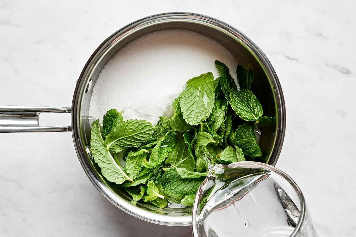 water, sugar and fresh mint leaves in a saucepan to make mint simple syrup
