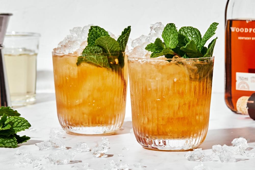 homemade juleps in glasses made with fresh mint, bourbon and simple syrup served over crushed ice with fresh mint leaves