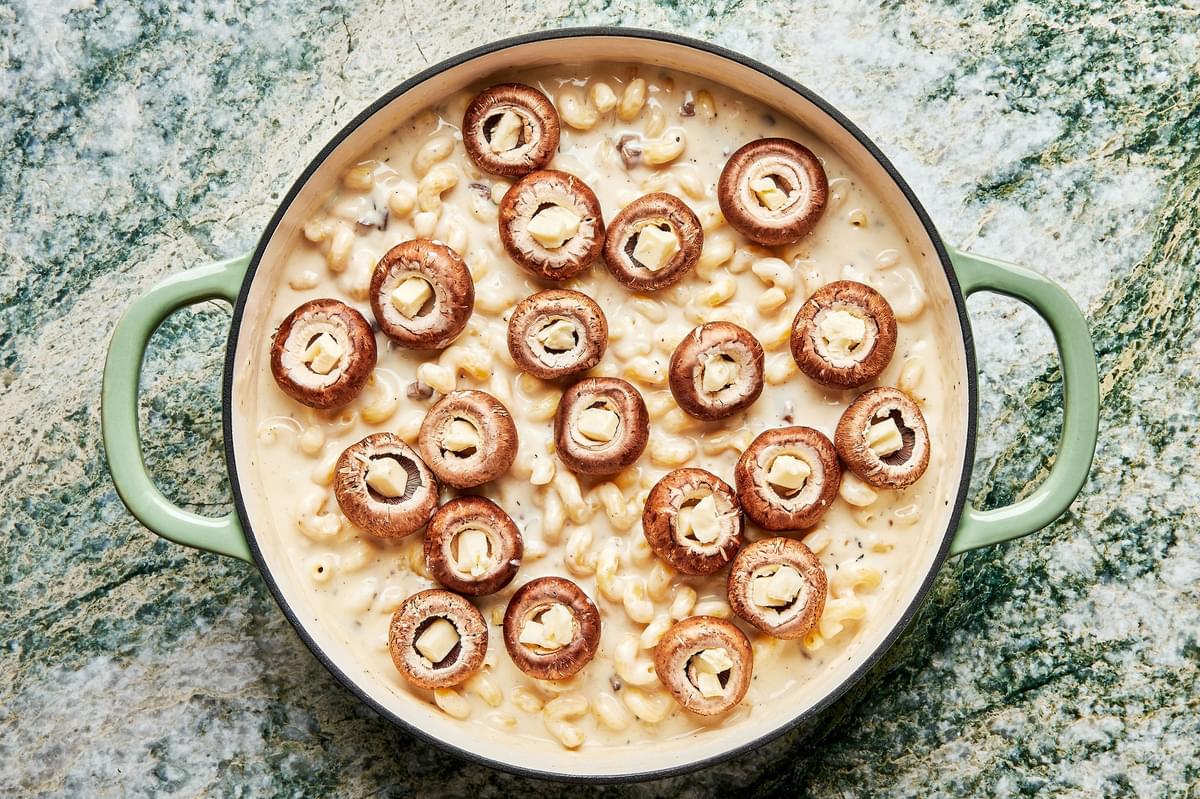 macaroni and cheese topped with mushroom tops filled with butter