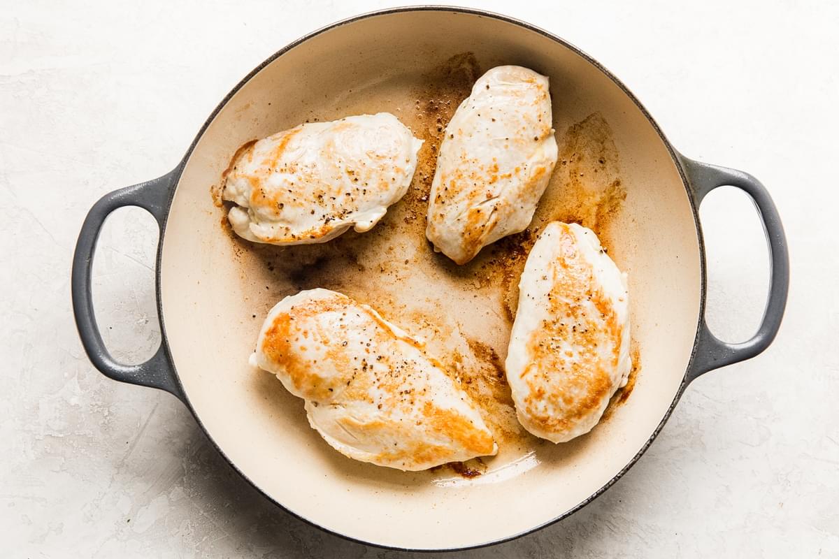 4 large chicken breasts seasoned with salt and pepper being browned in a pan