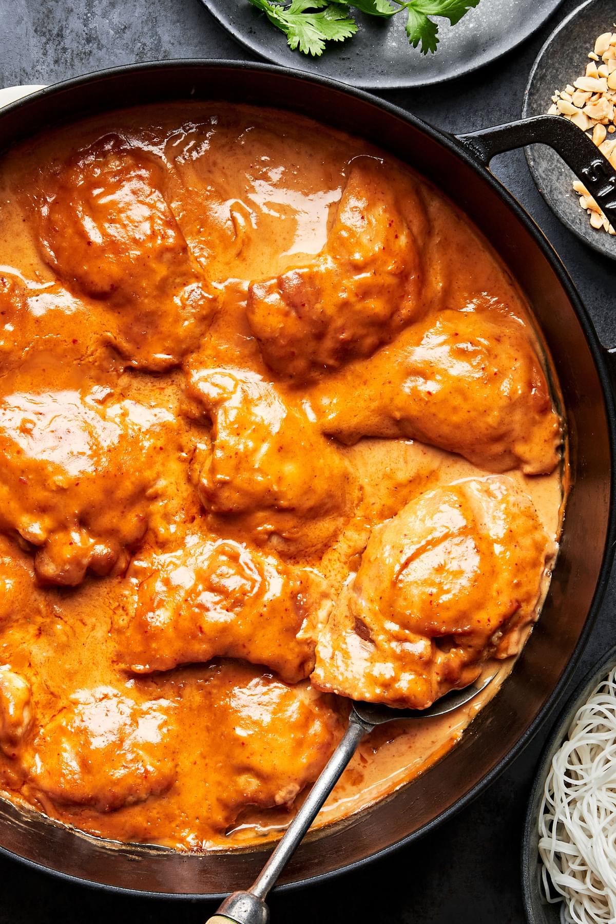 chicken being cooked in a skillet with homemade peanut sauce