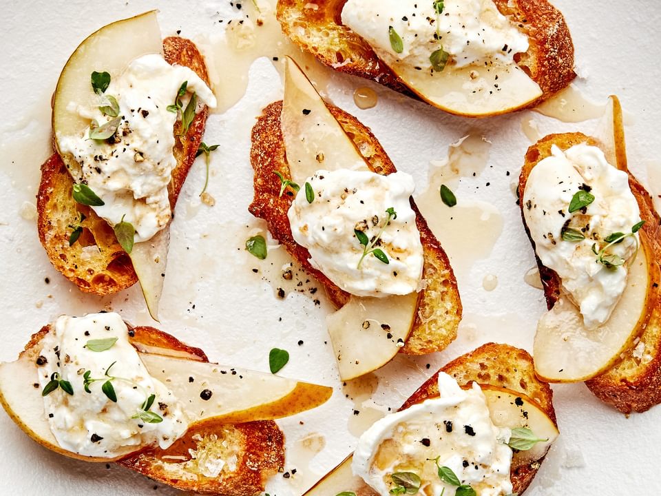 Pear and Burrata Crostini drizzled with sherry vinegar and honey and sprinkled with thyme, salt and pepper