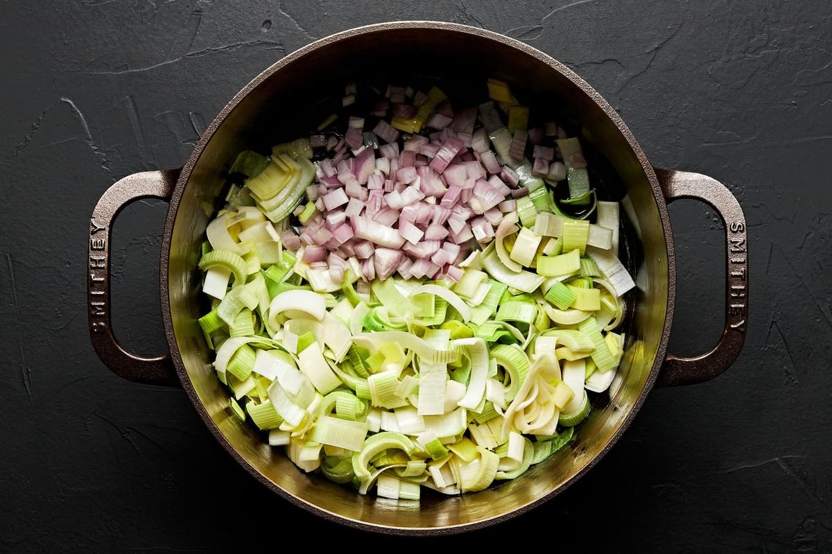 shallots and leeks cooking in a pot with butter and oil