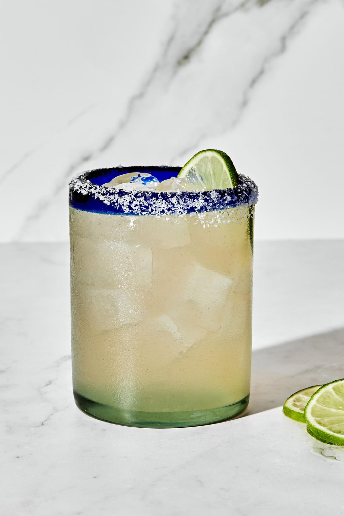 a margarita made with tequila, orange liqueur, lime juice and angostura bitters served with a salt rim and a lime wedge